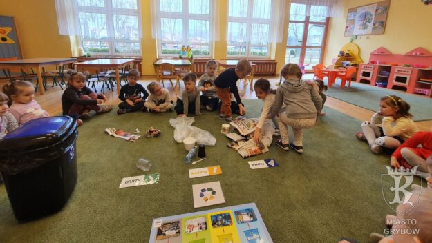 Światowy Dzień Recyklingu Grupka dzieci siedząca na dywanie poznaje różne rodzaje śmieci