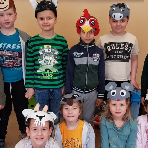 Dzieci pozują do zdjęcia z maskami zwierząt