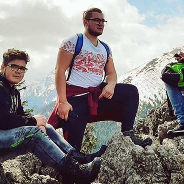 Trzech uczestników na jednym ze szczytów w wysokich górach