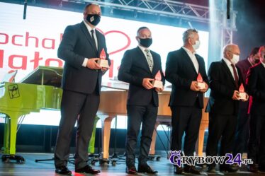Burmistrz na scenie jako wyróżniony prezentuje otrzymaną statuetkę