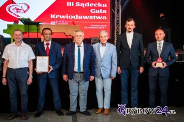 Odznaczeni i wyróżnieni ustawieni w szeregu przy scenie