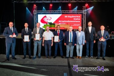 Odznaczeni i wyróżnieni ustawieni w szeregu przy scenie