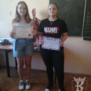 Uczennice klasy 8c - Patrycja i Kamila, prezentują otrzymane dyplomy