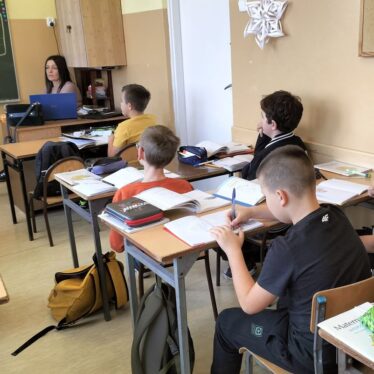 Uczniowie klas piątych w czasie pogadanki z policjantem