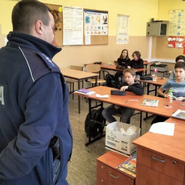 Uczniowie klas piątych w czasie pogadanki z policjantem
