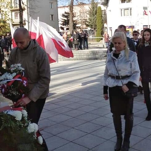 Delegacja składająca kwiaty przed Pomnikiem Pamięci w Parku Miejskim w Grybowie