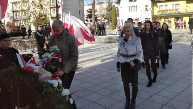 Delegacja składająca kwiaty przed Pomnikiem Pamięci w Parku Miejskim w Grybowie