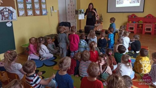 Autorka pokazuje dzieciom książkę z rozkładanymi elementami