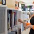 Pani stojąca przy bibliotecznej półce z książkami