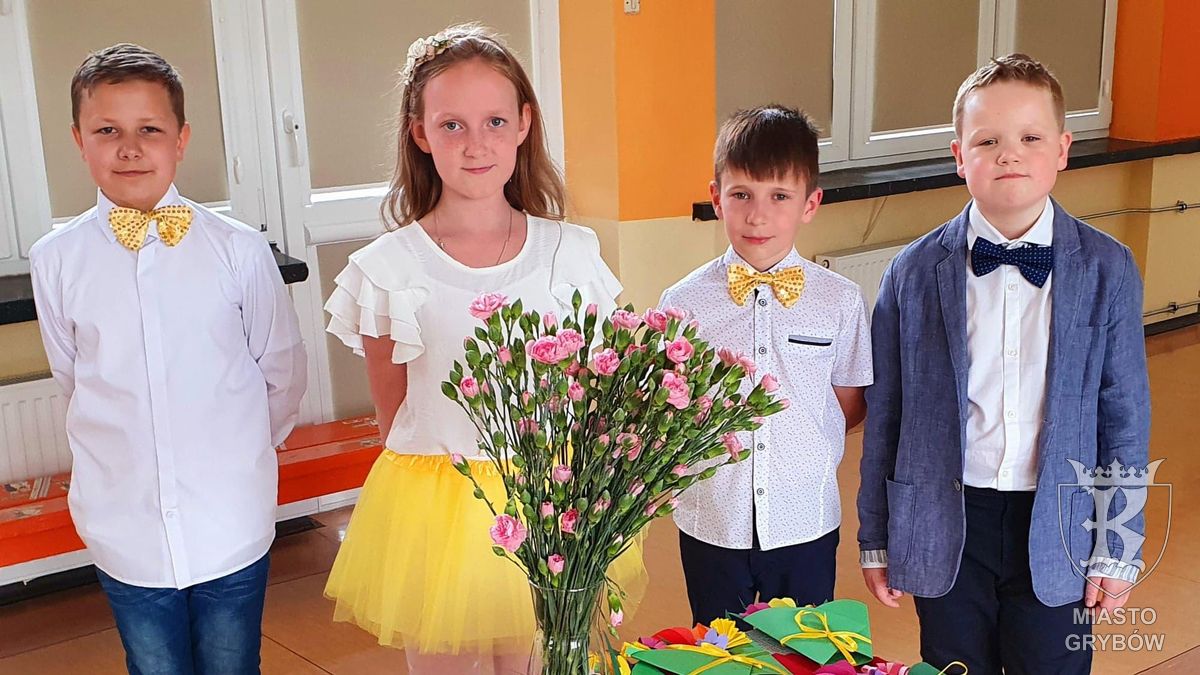 Uczniowie klasy 3d - przed nimi flakon z goździkami