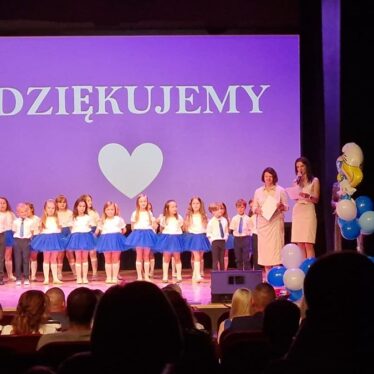 Pani Dyrektor wraz z Wychowawcą stoją na scenie i dziękują przybyłym rodzicom, dzieci stoją obok