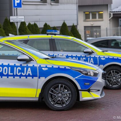 Widok od strony prawych drzwi na dwa radiowozy