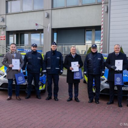 Przedstawiciele samorządu i policji na tle nowych radiowozów