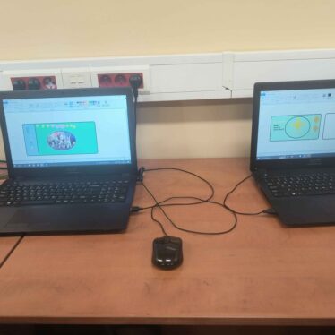 Zajęcia w klasie 3 - projektowanie banknotów i monet - dwa laptopy na stoliku