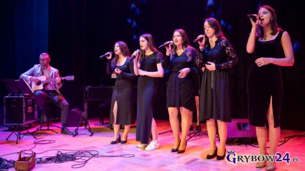 Grupa wokalna solistek śpiewa do mikrofonów