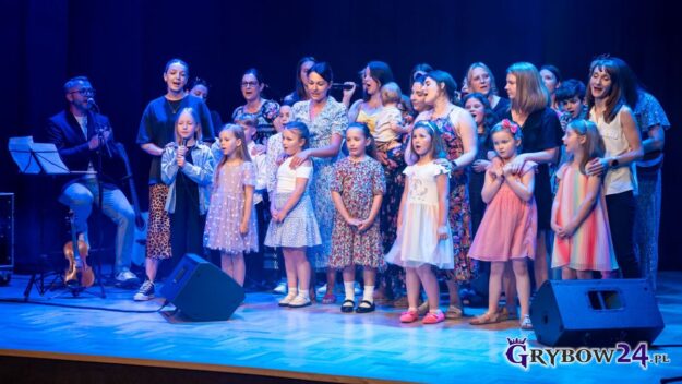 Zbliżenie na scenę - dzieci z chóru wraz ze swoimi mamami wspólnie śpiewają piosenkę
