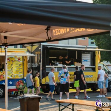Klienci stojący przed z foodtruckami