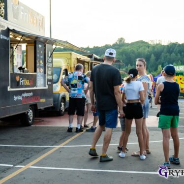 Klienci stojący przed jednym z foodtrucków