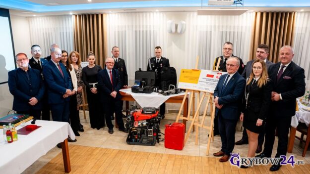 Zdjęcie grupowe strażaków i zaproszonych gości - na pierwszym planie sprzęt przekazany dla OSP