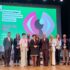 Wspólne zdjęcie grupy osób stojących obok siebie na scenie. W tle na ekranie napis „7. Małopolski Kongres Dyrektorów i Dyrektorek Domów Kultury”
