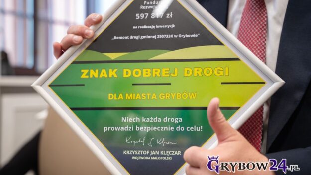 Burmistrz z uniesionym kciukiem prezentuje otrzymany znak