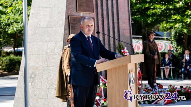 Przemówienie burmistrza przy mównicy podczas obchodów Święta Wojska Polskiego przy pomniku