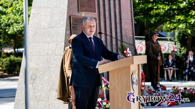 Przemówienie burmistrza przy mównicy podczas obchodów Święta Wojska Polskiego przy pomniku