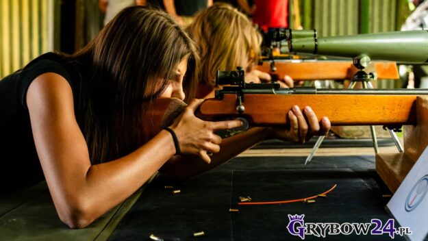 Strzeleckie zmagania o Puchar Burmistrza Miasta Grybów Młoda zawodniczka celuje z karabinka podczas zawodów strzeleckich na stanowisku w plenerze